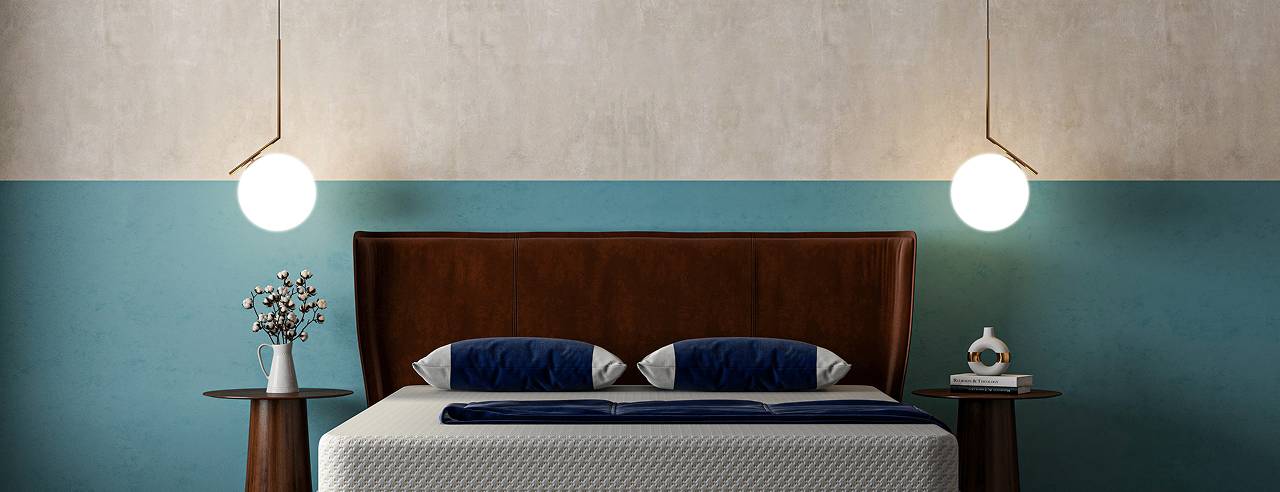 Lit moderne avec tête de lit en cuir, lampes suspendues et tables de chevet.